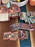 A collection of Yu-Gi-Oh! cards spread on a table with 2 empty redemption boxes visible and several empty plastic bags.