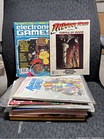 Stack of assorted gaming and comic magazines including Electronic Games 1983 Arcade Awards and Indiana Jones Official Collectors Edition