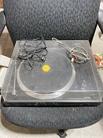 Top view of the closed turntable on a chair with cords placed on top.