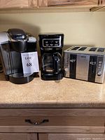 Photo of the three appliances on a kitchen counter: Keurig coffee maker, 12-cup programmable coffee maker, and Brevo 4-slice toaster.