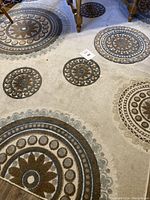 Photo showing full view of rug with circular designs in gray, blue and brown.