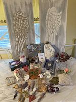 Wide view of the entire group showing two large angel wing wall art panels and various small handmade craft items including fabric hearts, wooden plaques, and decorative pieces.