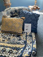 Quilt and coordinating pillows arranged on bed, showing pattern and colors clearly.