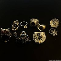 Photo of all 8 silver tone women's rings with various designs on black background