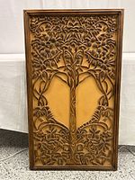 Full view of the large rectangular hand carved wooden panel with Tree of Life design showing symmetrical tree trunk, branches, leaves and fruit, framed with a narrow carved wood border.