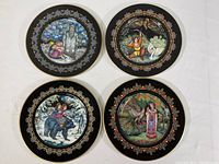 All four plates arranged in a square, showing the detailed artwork on black background with decorative borders