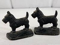 Pair of black cast iron Scottish Terrier bookends displayed together showing front and side views.