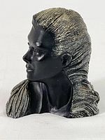 Front angled side view of the black resin bust sculpture showing facial features and textured hair with silver-tone finish.