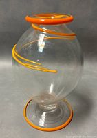 Front angle shot of the clear glass vase showing the orange swirl accent and orange base ring