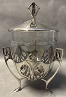 Front view of assembled biscuit barrel with lid on, showing overall shape, handles, feet and condition