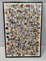 Full view of the framed abstract oil painting on board showing dense splattered paint in multiple colors and black frame.