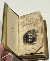 Photo of the open book showing front page with detailed engraving and title 'Domestic Cookery for the Use of Private Families by a Lady Mrs Rundell' published in Manchester by Thomas Johnson.