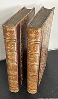 Two leather bound books standing side by side, showing spine titles 'British Battles' and 'Vol I, Vol II'. Books have marbled covers and wear on edges.