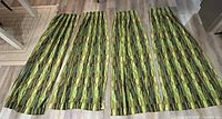Four MCM retro style drape panels laid out flat on the floor showing full length and pattern.