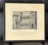 Framed etching showing stone cloisters and buildings with signature and title visible on margins.