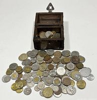Wooden chest open on white surface with coins spilled out