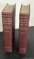 Side view showing maroon spine of two hardcover books titled The First World War 1914-1918 with author Colonel Repington and volume numbers I and II. Publisher Houghton Mifflin Co.