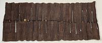 Full set of chisels inserted in brown suede roll-up pouch