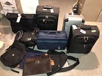 Full view of all luggage items arranged on floor showing variations in color, size, and style
