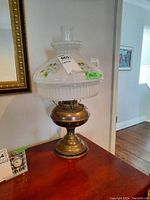 Oil lamp with metal base and floral glass shade in situ, showing full height and details