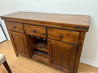 Front view of entire buffet showing drawers, doors, finish and metal accents