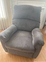 Front view of gray recliner chair showing padded seat, backrest, and arms in gray tweed fabric.