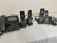 Full view of the set showing two main bases, each wired, with four cordless handsets placed in their charging docks