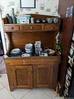 Front view of dry sink with drawers and cabinet, showcasing some contents on the recessed middle section surface.
