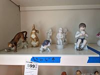 Full lot view showing all six figures: five children figurines by Bing and Grondahl, one cat figurine marked Goebel, and one unmarked rabbit figurine.