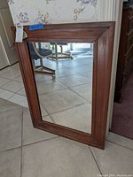 Front view of the rectangular wooden framed mirror showing the frame and reflective surface.