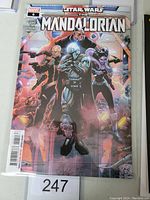 Front cover photo of The Mandalorian #6 Marvel comic book in protective sleeve showing main characters from the Star Wars series.