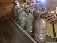 Five stacked prismatic glass shades with metal reinforcement cages seen from side view