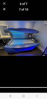 Sunbed open showing interior UV lamp array and acrylic tanning surface
