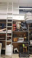 Photo showing the full extended aluminum extension ladder against shelving units.