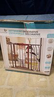 Photo of box front showing Summer Anywhere Decorative baby gate with image of gate and child, brand and product name.