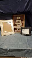 Three items shown: large beige ornate picture frame, tin wall art with chicken and farm words, small black ornate picture frame.
