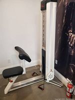 Side view showing white frame, black seat and angled preacher pad.