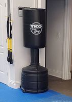 Full view of the TKO Fat Boy free standing kicking and punching bag with black padded striking surface and weighted base.