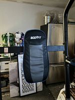 Close-up of padded backrest with Bodyfit branding on exercise station