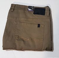 Folded tan Buffalo David Bitton Sam-X jeans showing back pocket, leather brand patch and label on the waistband.