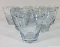 Six clear whiskey glasses arranged together showing the star and dot atomic design around the rim.