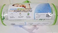 Image showing the full pillow rolled up with packaging label describing cooling bamboo memory foam pillow, removable zippered cover, pressure relief, hypoallergenic features.