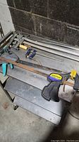 Overview of 6 clamps on metal cart showing varied types including Quick-Grip and bar clamps.