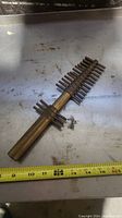 Large brass gasket hole punch with multiple prongs in rows, measuring about 10 inches