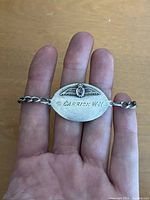 Front side of sterling silver bracelet showing wing insignia and engraved name '2/C Carrick W.H.'