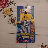 Front view of the Bananas In Pajamas finger puppet attached to original packaging featuring colorful Tomy branding and character graphics.