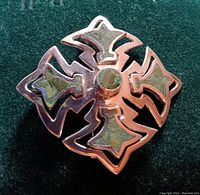 Front view of the vintage sterling silver pendant/brooch showing the cross-shaped design with textured and smooth finishes.