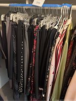 Rack of women's skirts and dresses in dark and patterned fabrics taken from the side.