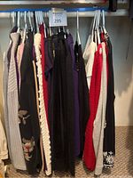 View of assorted women’s sweaters and cardigans on hangers showing variety of colors and knit textures