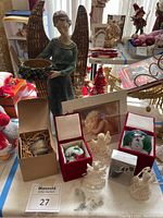 Overview of the lot showing large decorative angel figurine, framed sleeping angel print, and grouped ornaments including glass and macrame angels